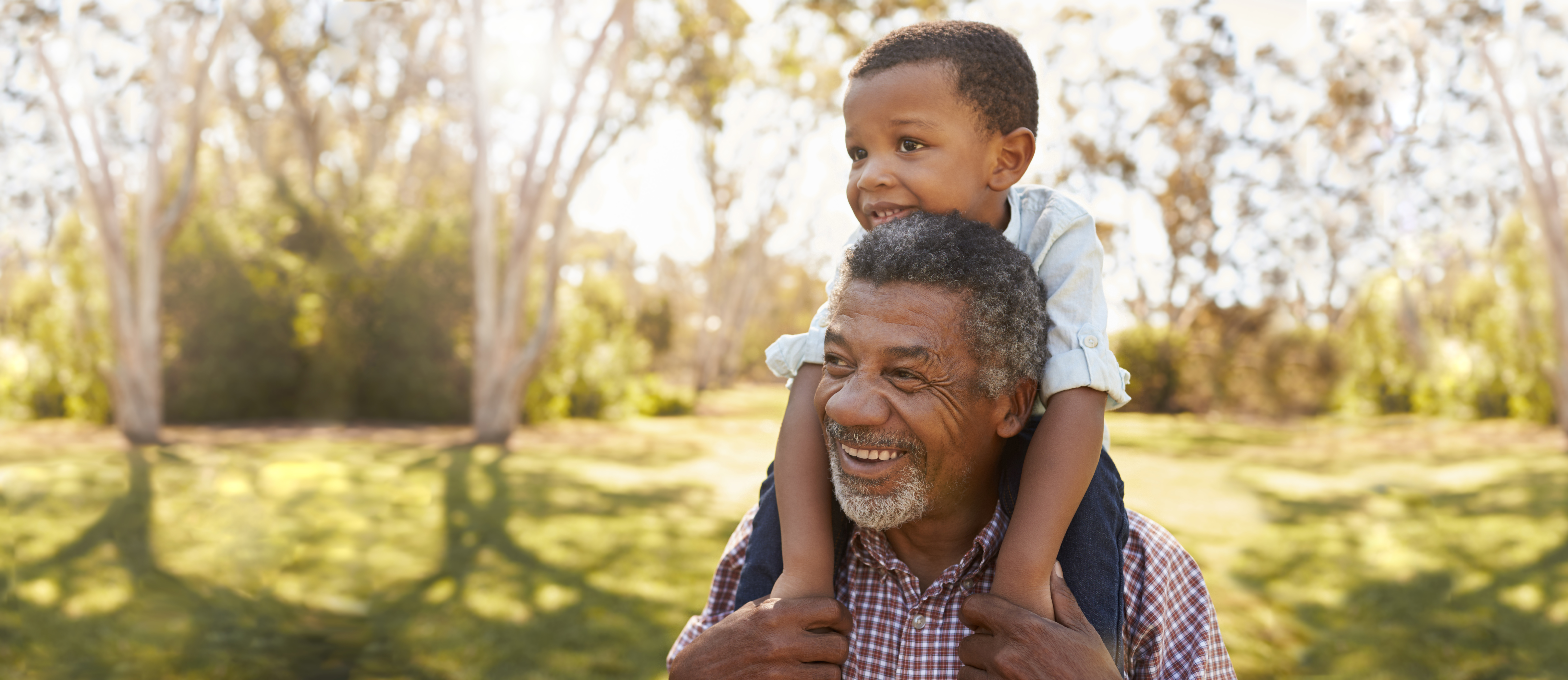 Man with grandson on his shoulders smiling